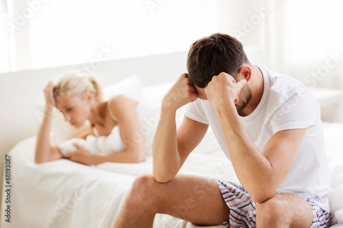 unhappy couple having problems at bedroom