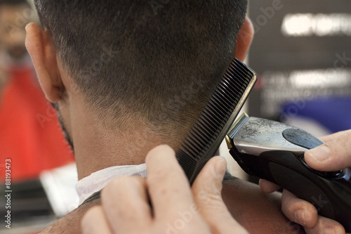 Fotografie Un parrucchiere mentre taglia i capelli