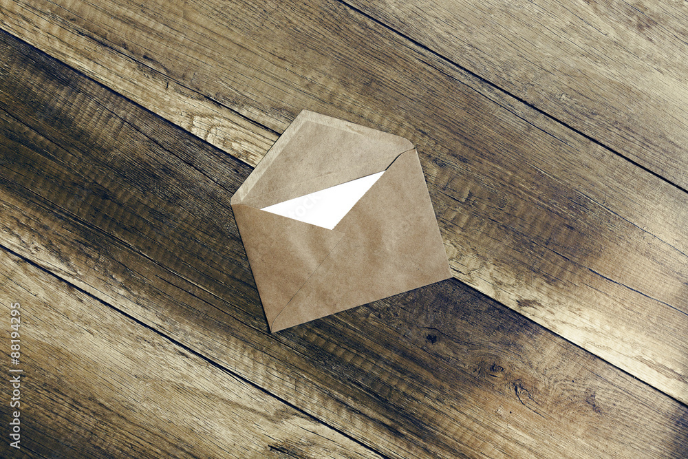 Fototapeta premium envelope.the envelope of brown paper with a blank white form on wooden background