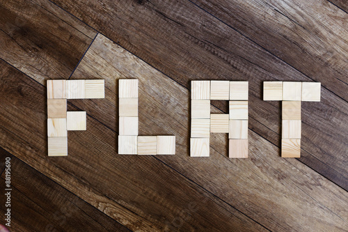 flat. the word "flat" lined cubes on wooden background