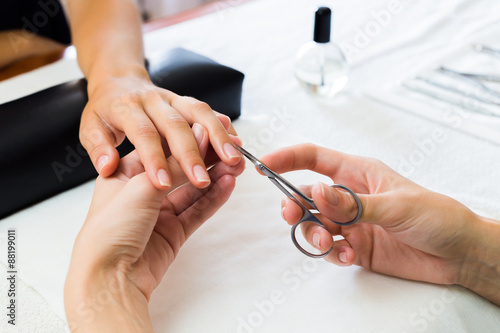 Manicurist trimming a clients cuticles