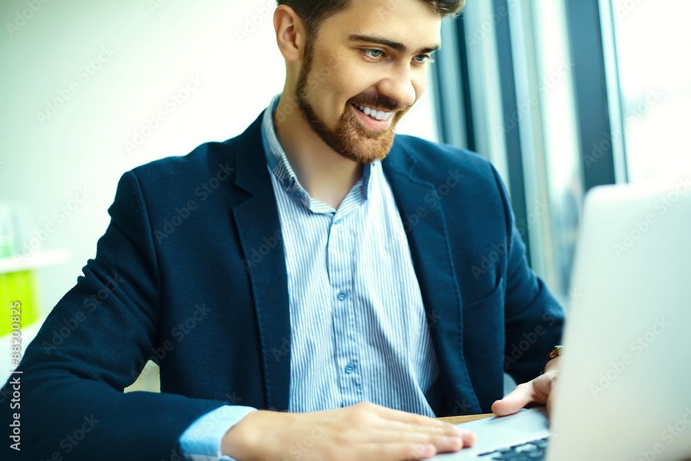 Young fashion smiling hipster man in the city cafe during lunch time with notebook in suit Young fashion smiling hipster man in the city cafe during lunch time with notebook in suit