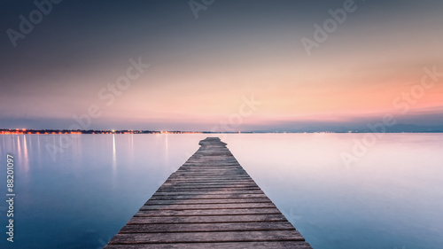 Fototapeta Naklejka Na Ścianę i Meble -  Long Wooden Wharf on Garda lake at sunset