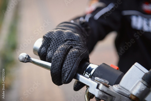 Valokuvatapetti protective biker gloves on a motorcycle wheel