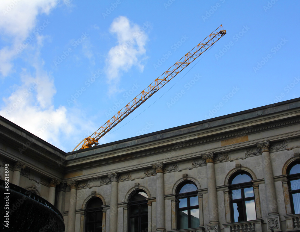 Fototapeta premium Part of the old building and construction crane boom