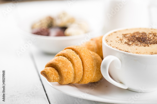 Hot cappuccino and pastries on white wooden boards Fototapeta