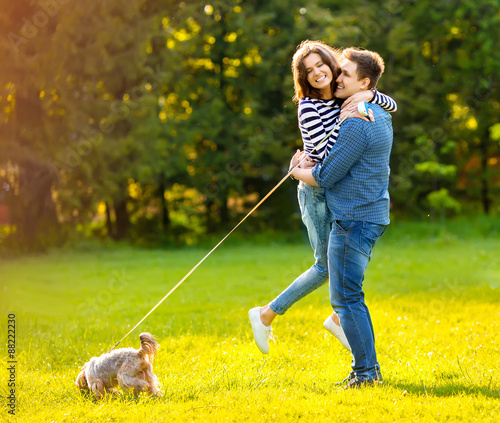 Lifestyle, happy couple of two walk on a sunny day in the park with a dog