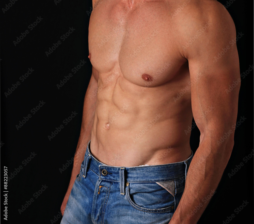 Strong Athletic Man  showing six pack abs on black background