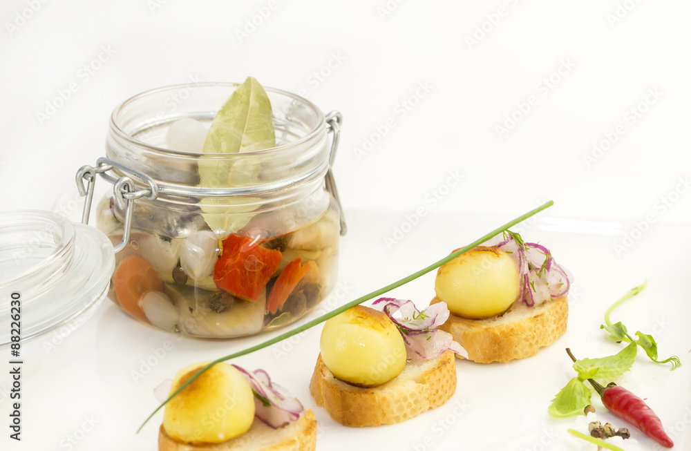 pickled herring in a glass jar with potato canapes pickled herring in a glass jar with potato canapes
