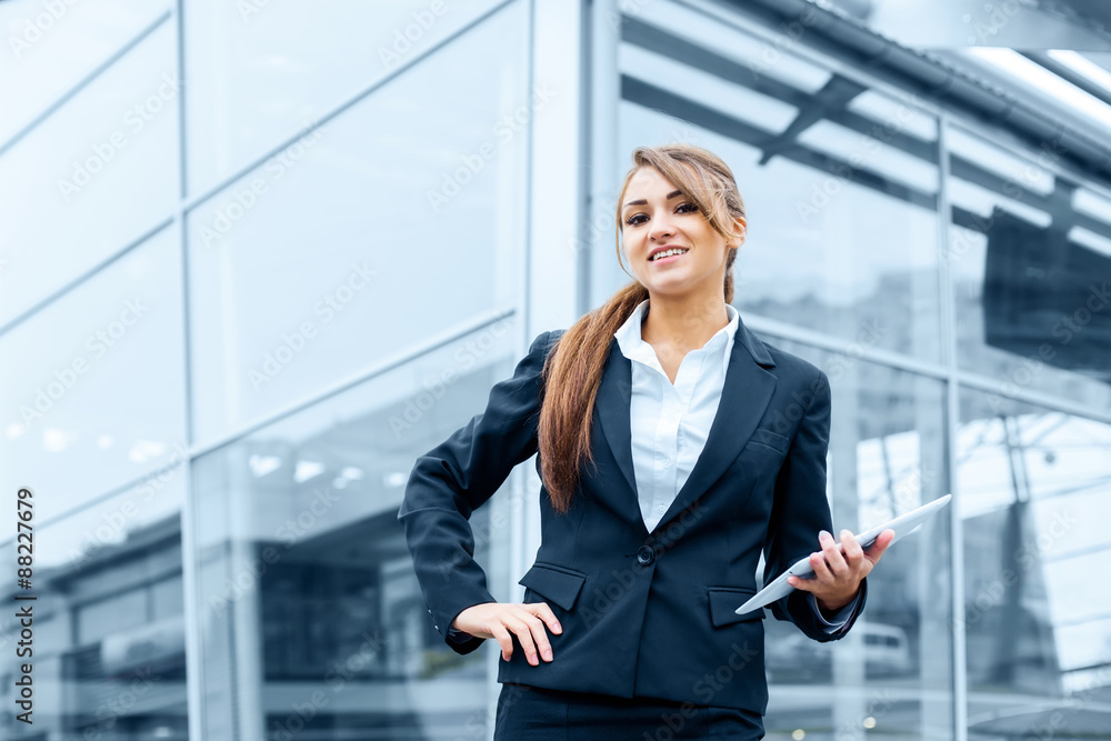 Successful businesswoman or entrepreneur using a digital tablet computer, standing in front of his office. Successful businesswoman or entrepreneur using a digital tablet computer, standing in front of his office.