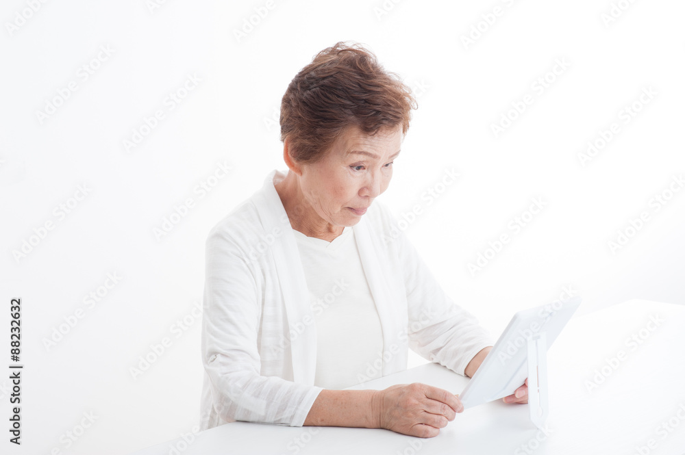 鏡を見てスキンケアをしているシニアの女性