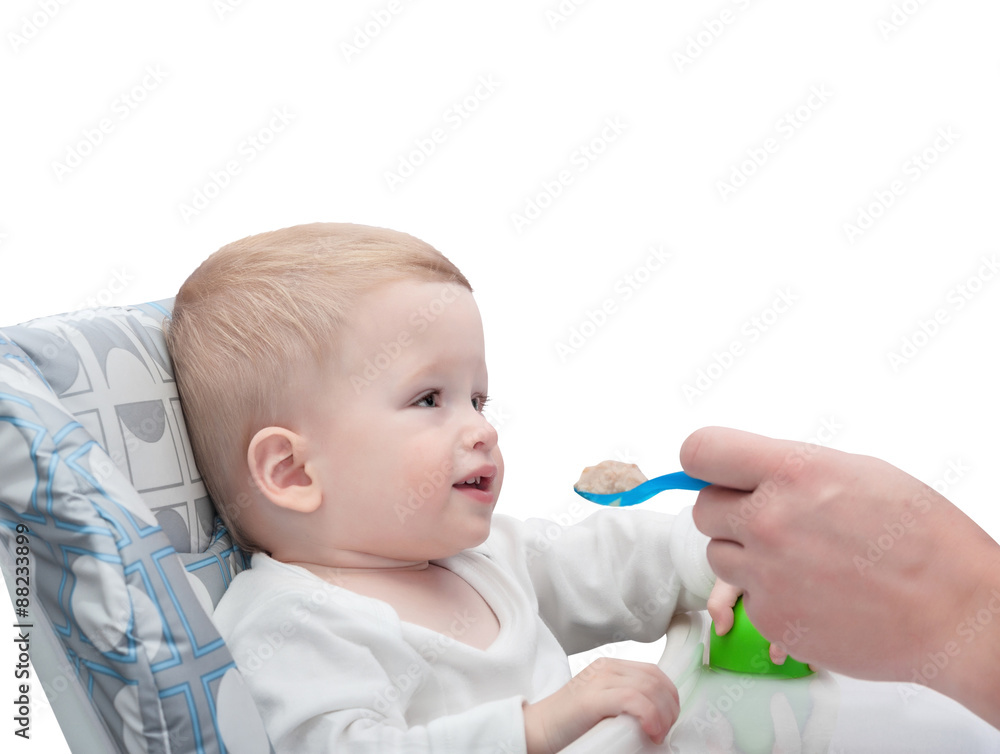 The father feeds with porridge of the one-year-old kid, isolated on white background The father feeds with porridge of the one-year-old kid, isolated on white background