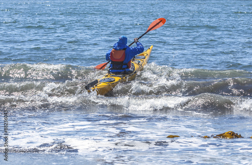 Kayakers on sand coast of Pacific ocean