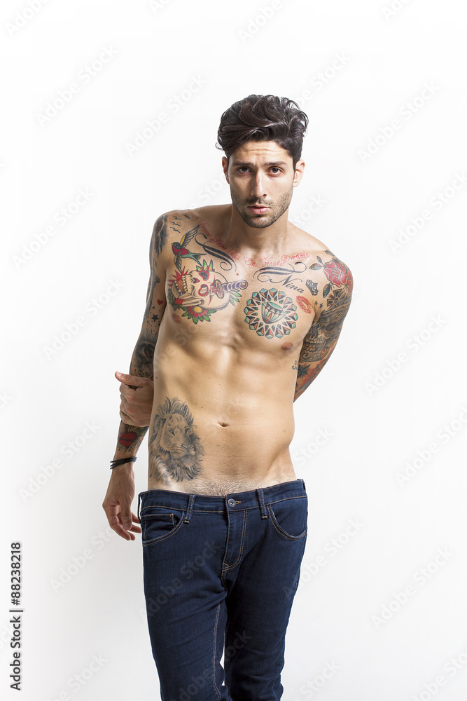Fototapeta premium Handsome and sexy tattooed man portrait wearing blue jeans
