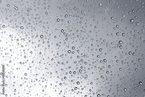 Rainy storm water drop on glass mirror background.