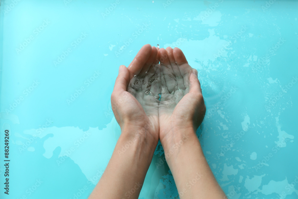 Female hands over clear water background Female hands over clear water background