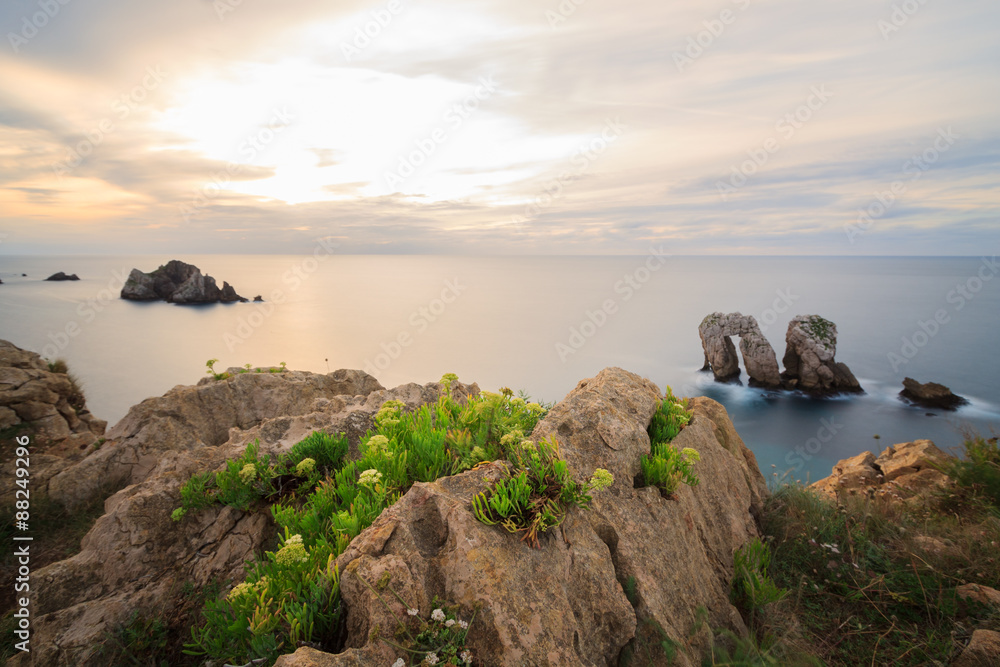 The sun is falling behind the horizon in liencres beach.