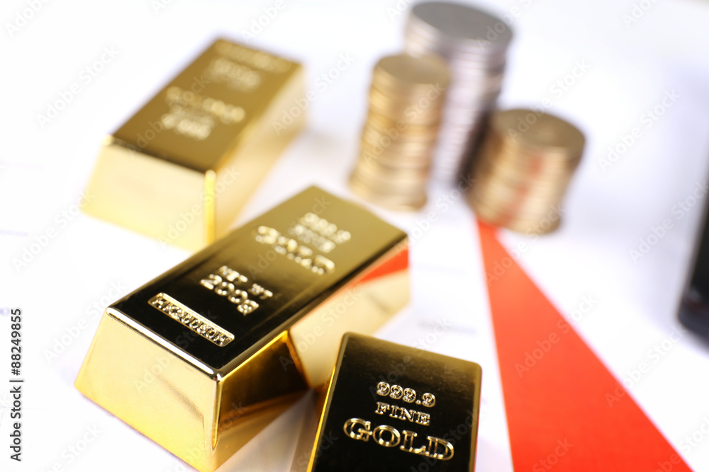 Gold bullion with coins on documents background Gold bullion with coins on documents background