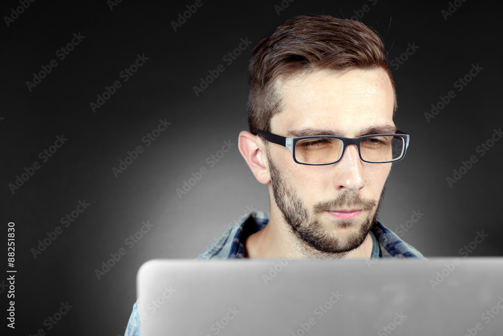 Handsome young man with laptop on grey background Handsome young man with laptop on grey background