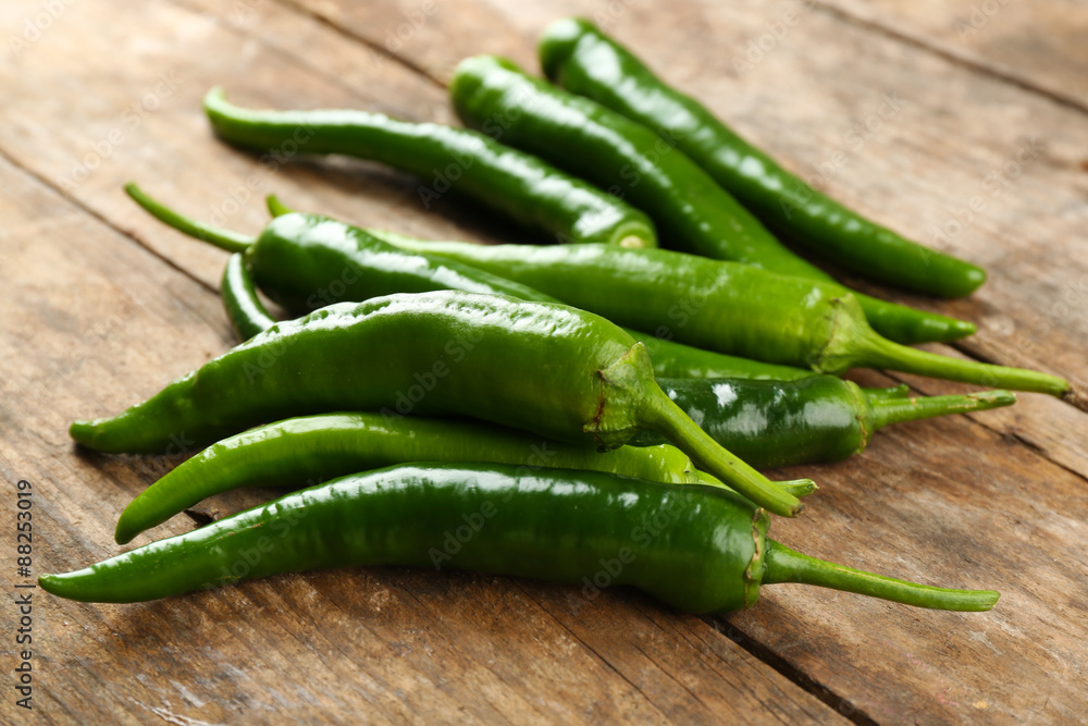 Green hot peppers on wooden table close up Green hot peppers on wooden table close up