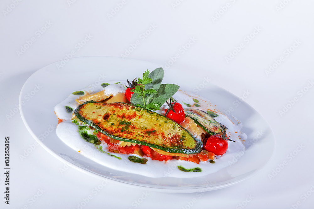 Ravioli mit Grillgemüse auf Trüffelölschaum mit Tomaten Nahaufnahme Ravioli mit Grillgemüse auf Trüffelölschaum mit Tomaten Nahaufnahme
