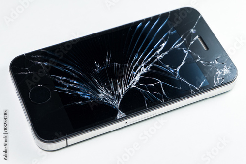 Broken screen mobile smartphone isolated on white background. © badztua