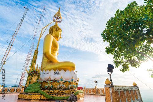 Big Golden Buddha statue against blue sky