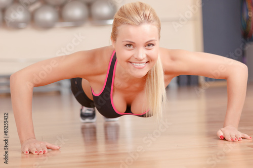 Nice woman doing push ups in gym