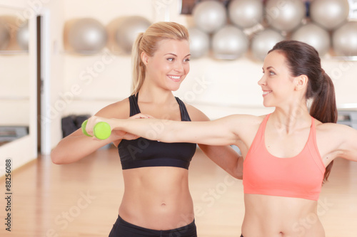 Fitness instructor helping woman in gym