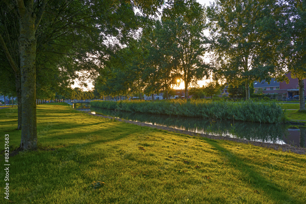 Sunset over a residential area along a canal in summer