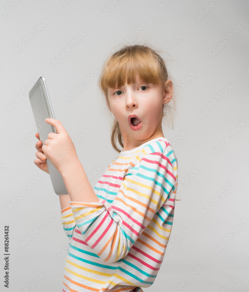 Surprised little girl and her tablet Surprised little girl and her tablet