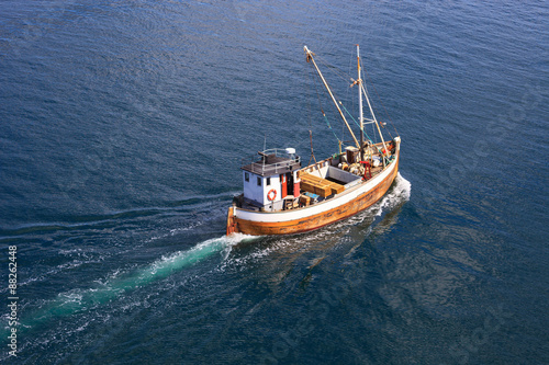Old wooden fishing boat trawler on sea.