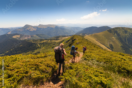 A group of people with backpacks walking along the road.