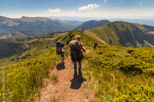 A group of people with backpacks walking along the road.