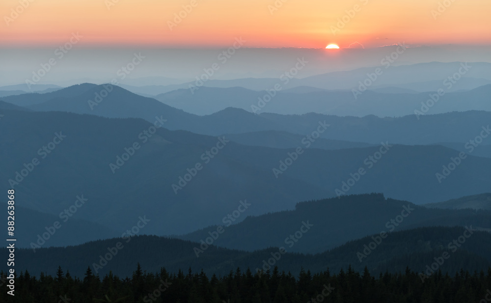 Distant mountain range and thin layer of clouds on the valleys