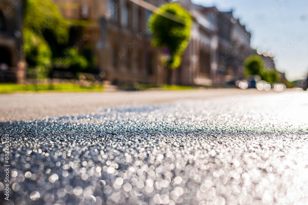 Φωτογραφία City on a sunny day, a quiet street after rain with trees and cars