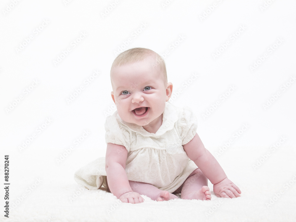 Bimba sorride felice, seduta sulla coperta Bimba sorride felice, seduta sulla coperta