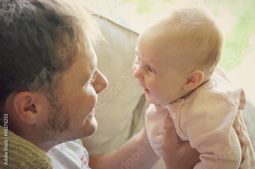 Young Father Playing with Newborn Baby Girl photo