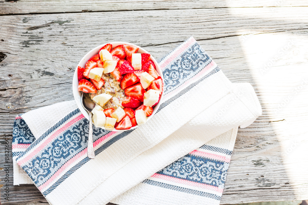 Fototapeta premium oatmeal with poppy seeds, raisins, strawberries and banana