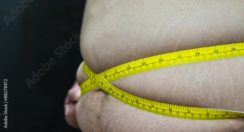 Fat Asian male with measuring tape side view