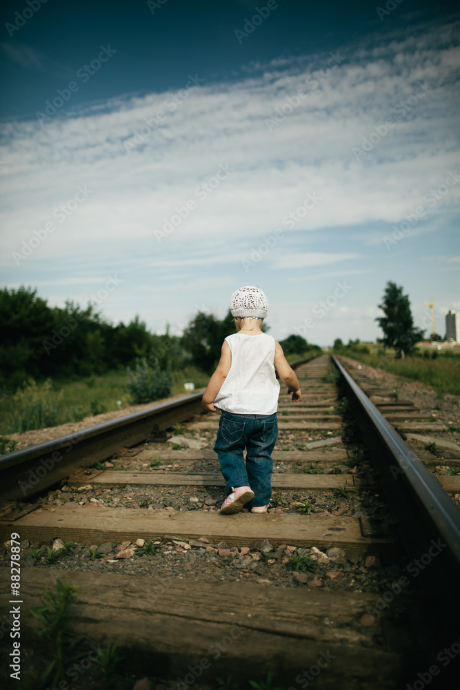 little girl plays on railroad