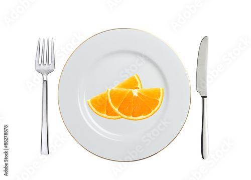 white plate, orange slices, spoon and fork isolated on white