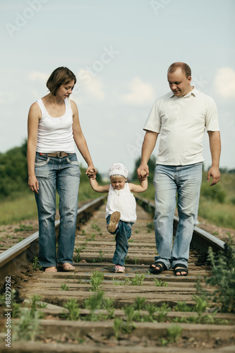 parents with baby on railroad