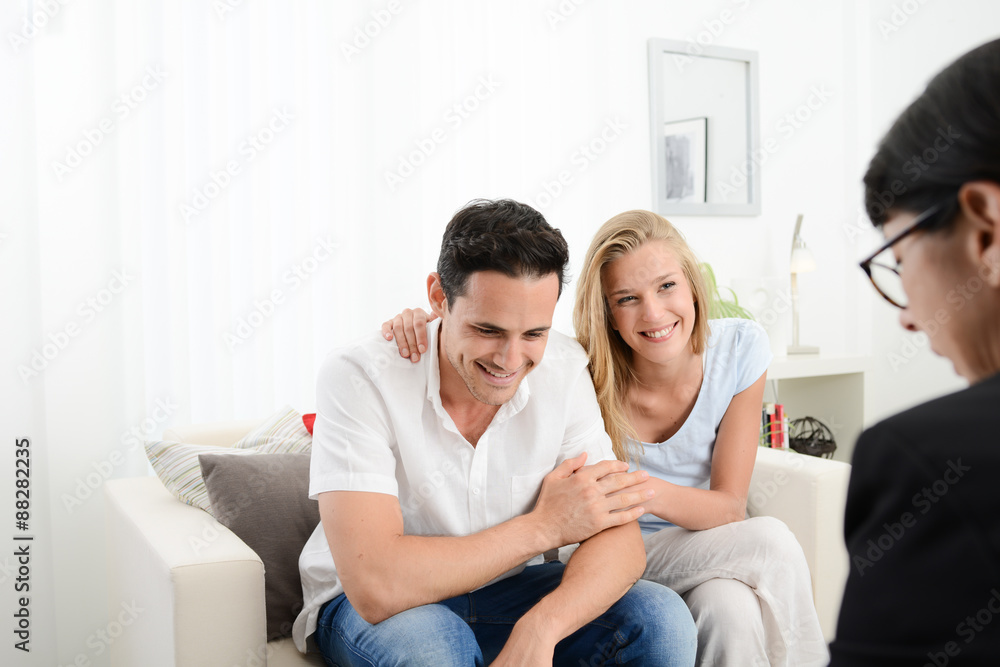 happy young couple at home in transaction signing contract with a business woman happy young couple at home in transaction signing contract with a business woman