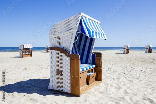 Wicker roofed beach chairs at the seashore