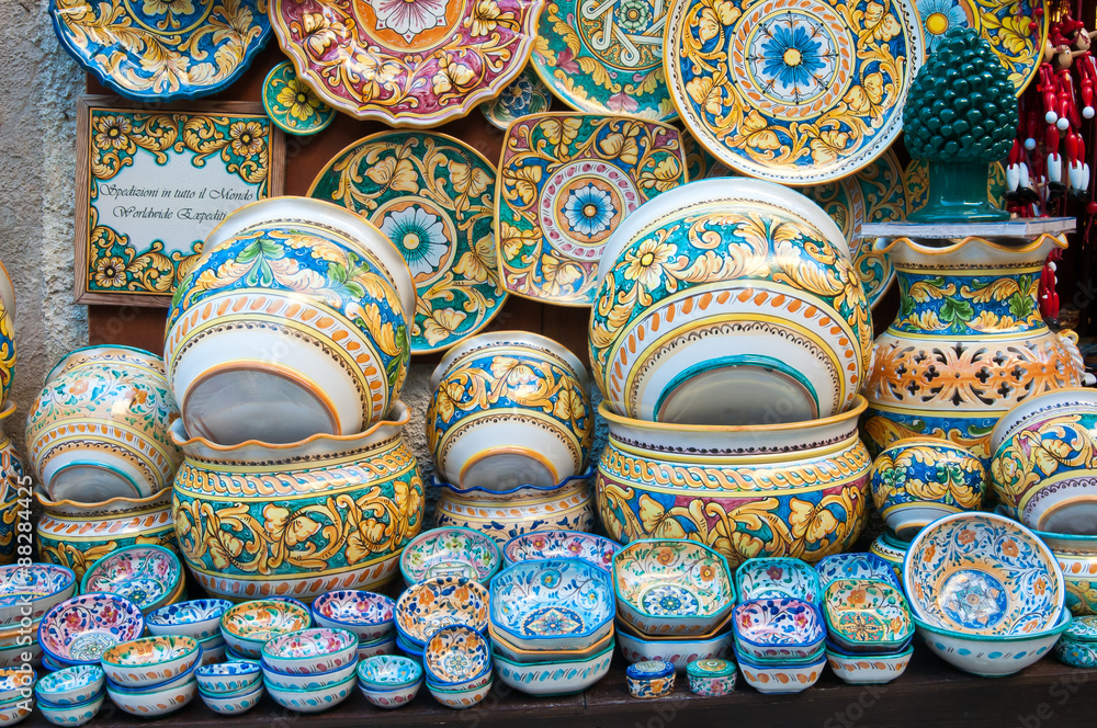 Various decorated ceramic dishes, vases, and bowls for sale outside a souvenir shop in Erice, Sicily