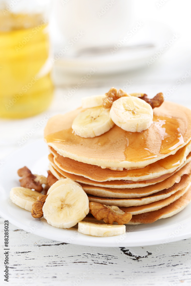 Tasty pancakes with banana and walnut on white wooden background Tasty pancakes with banana and walnut on white wooden background