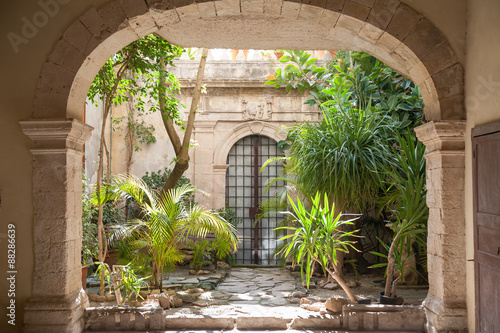 Fotobehang Courtyard of an old baroque palace and plants in the old Syracuse