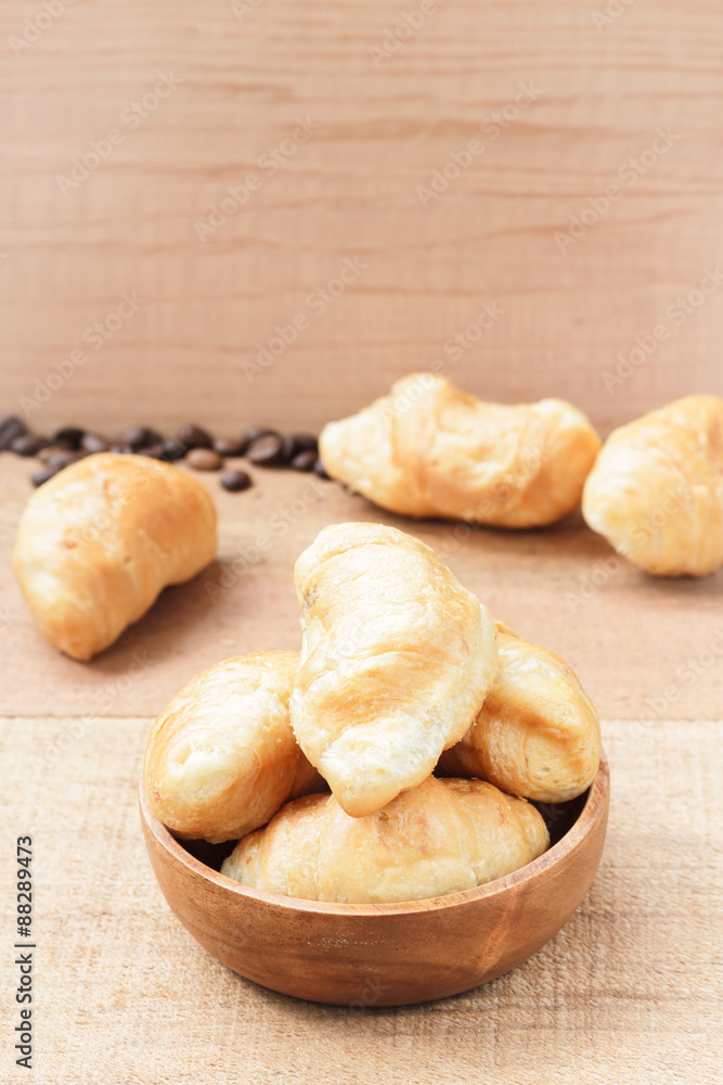 Croissants on wooden bowl, wooden table background Croissants on wooden bowl, wooden table background