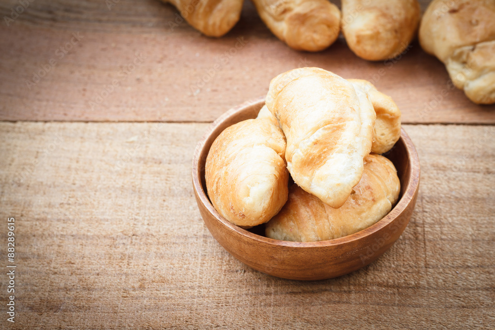 Croissants on wooden bowl, wooden table background Croissants on wooden bowl, wooden table background